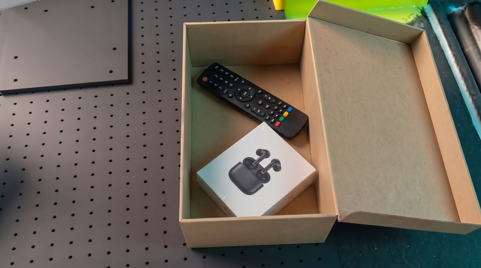 La caja abierta con auriculares y mando de TV