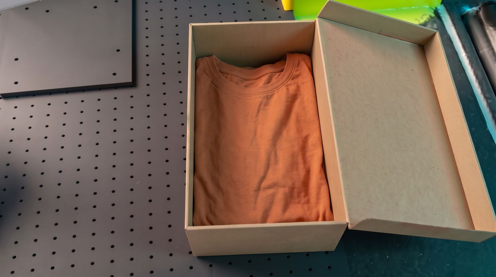 La caja abierta con camiseta de manga larga teja
